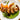 Roasted rabbit loin on a white plate with carrot ribbons and pea puree.